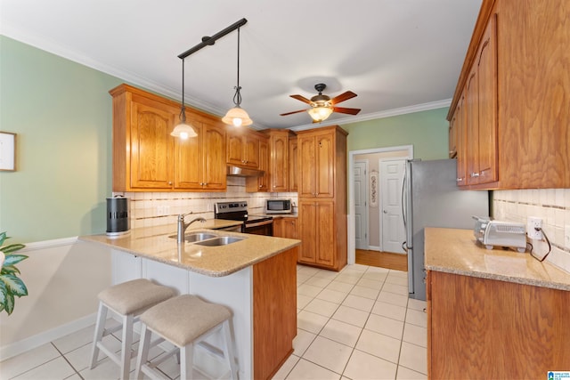 kitchen with stainless steel appliances, sink, kitchen peninsula, backsplash, and crown molding