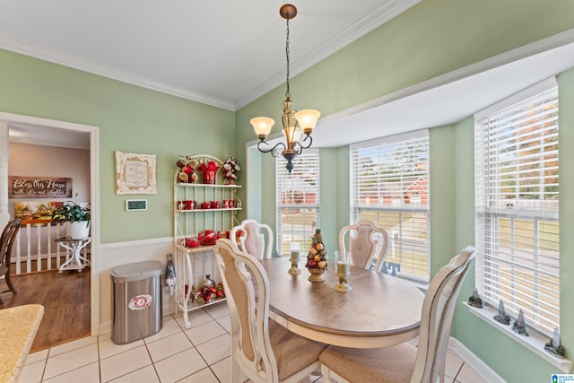 dining area with light tile patterned flooring, an inviting chandelier, and ornamental molding