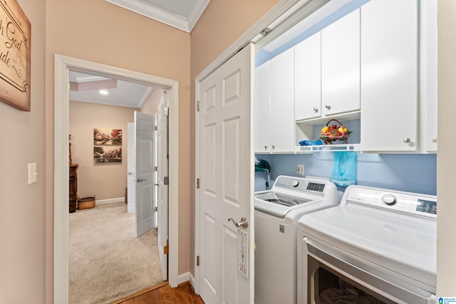 laundry room featuring cabinets, washing machine and clothes dryer, crown molding, and light wood-type flooring