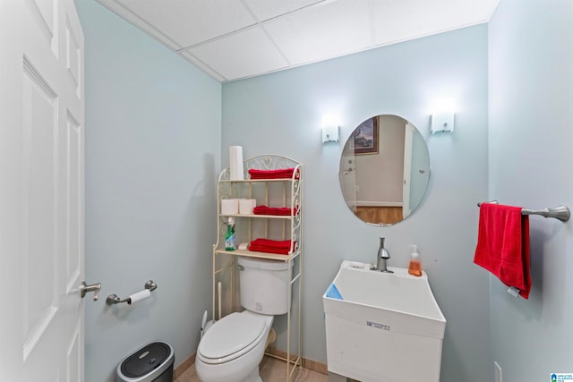 bathroom with a drop ceiling, vanity, and toilet