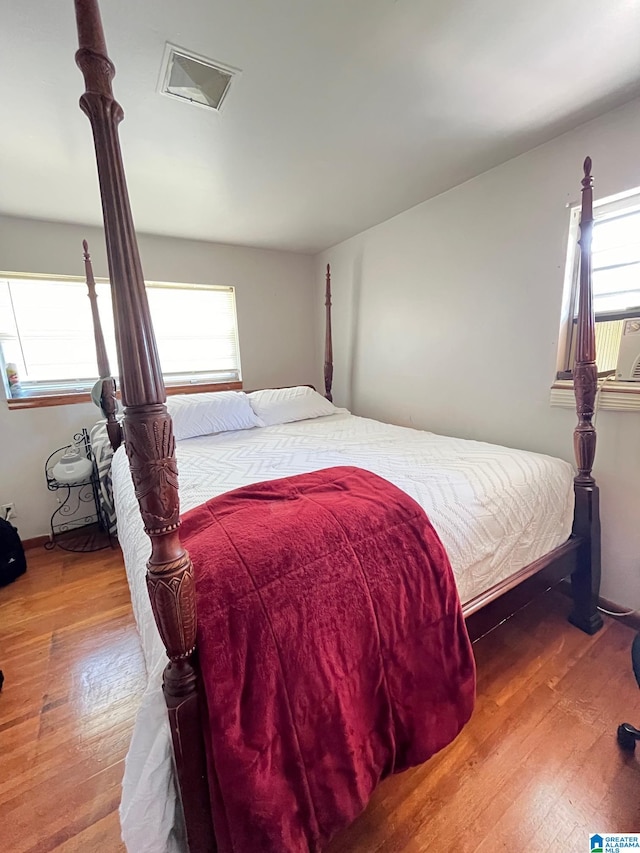 bedroom with wood-type flooring and multiple windows