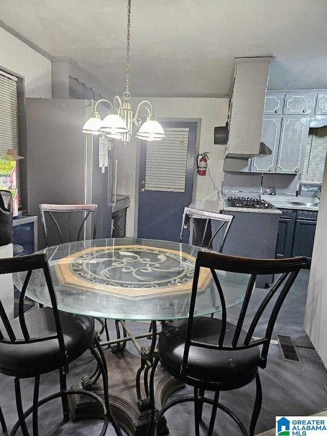 dining space featuring a notable chandelier and wood walls