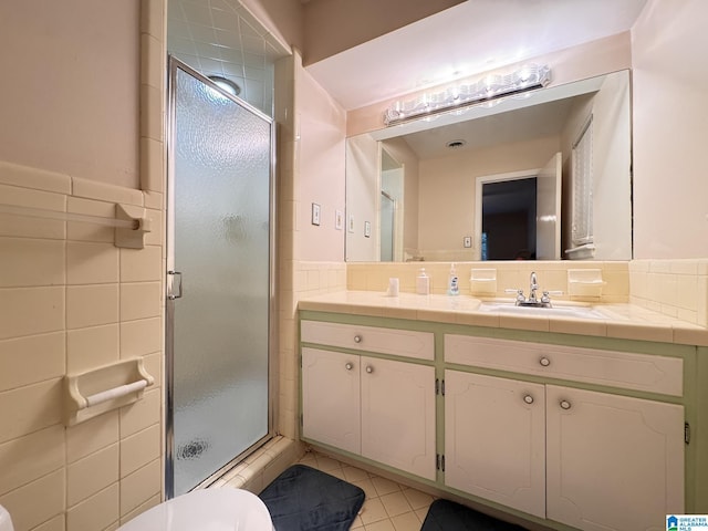 2082 Montreat Cir Unit 2082, Vestavia Hills, AL 35216 - bathroom with tile walls, a shower stall, tile patterned flooring, double vanity, and a wainscoted wall