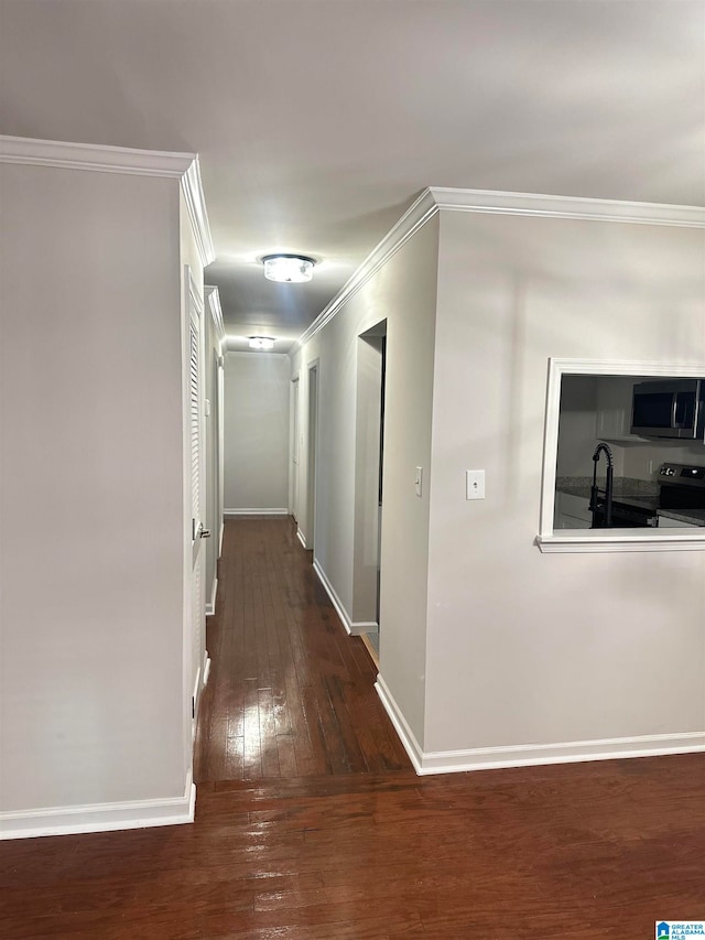 hallway featuring ornamental molding and dark hardwood / wood-style floors