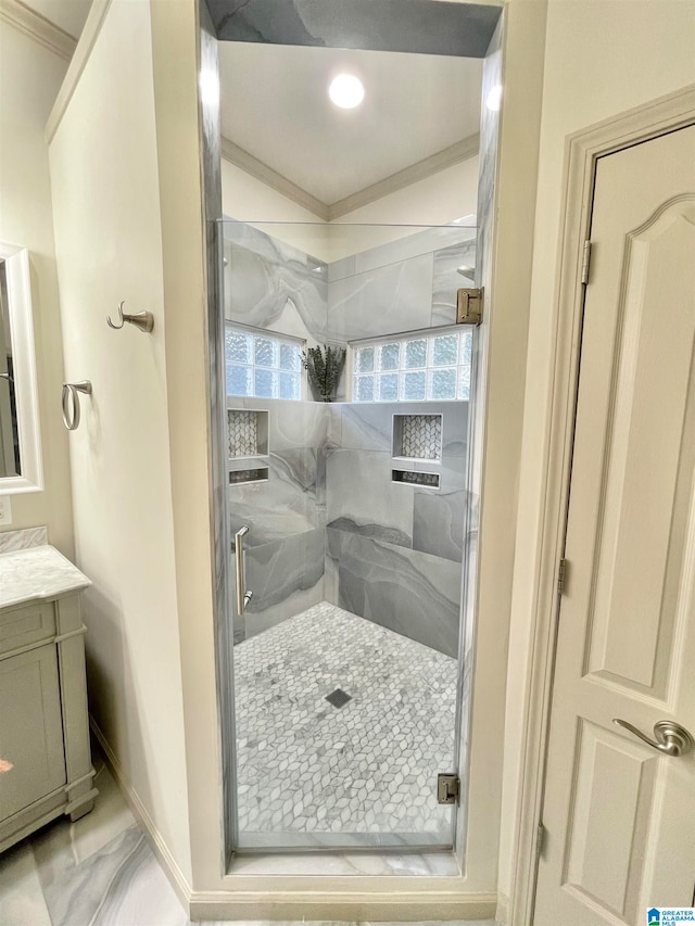 bathroom with a wealth of natural light, vanity, crown molding, and walk in shower