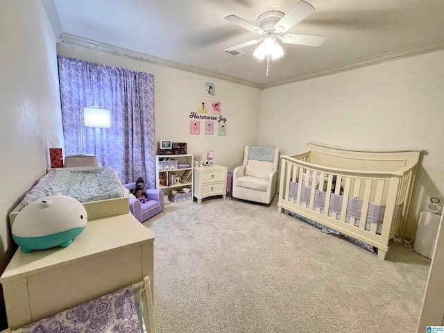 bedroom featuring crown molding, a crib, carpet flooring, and ceiling fan