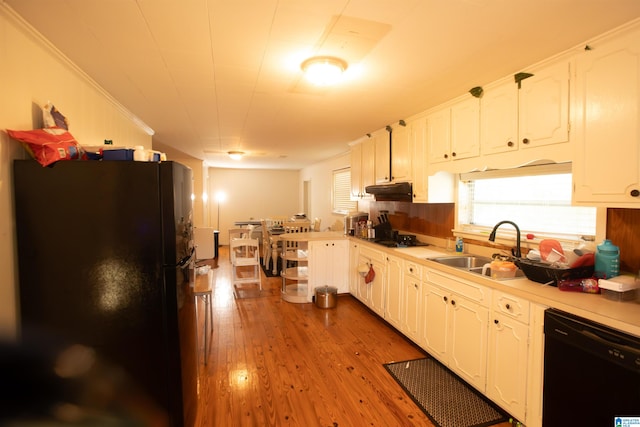 kitchen featuring sink, black appliances, white cabinets, and light wood-type flooring