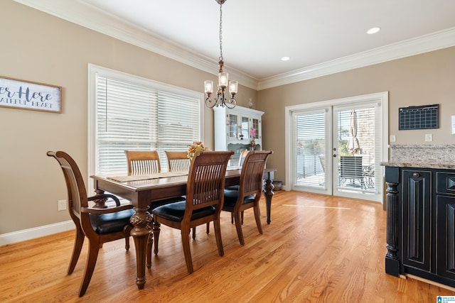 dining area featuring light hardwood / wood-style flooring, french doors, a chandelier, and crown molding