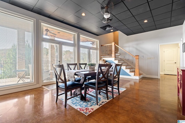 dining space with concrete floors, a drop ceiling, and plenty of natural light