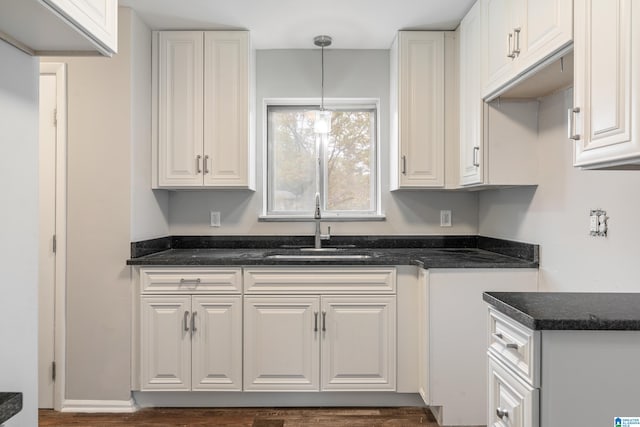 kitchen with hanging light fixtures, sink, dark hardwood / wood-style floors, and white cabinets