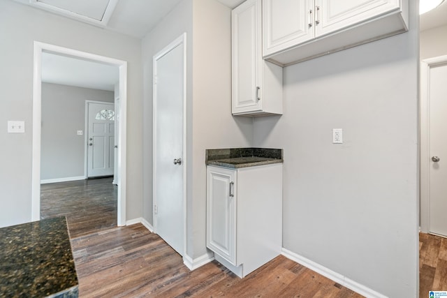 kitchen featuring white cabinetry, dark stone countertops, and dark hardwood / wood-style flooring