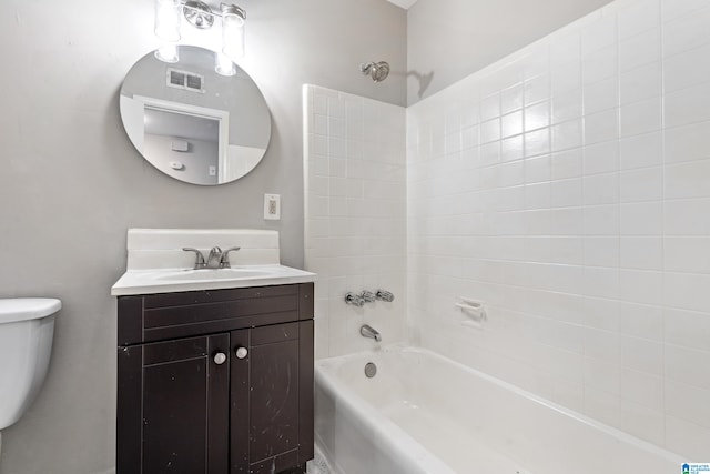 full bathroom with toilet, tiled shower / bath, and vanity