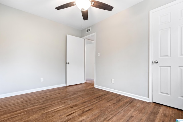 unfurnished bedroom featuring ceiling fan and dark hardwood / wood-style flooring