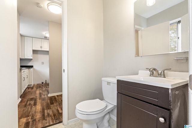 bathroom featuring vanity, hardwood / wood-style floors, and toilet