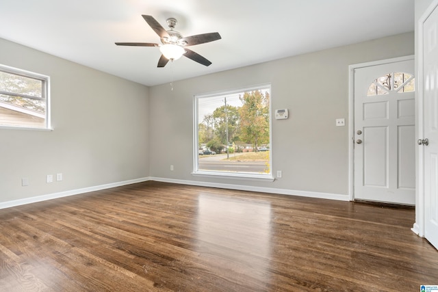 entrance foyer featuring dark wood-type flooring, ceiling fan, and a healthy amount of sunlight