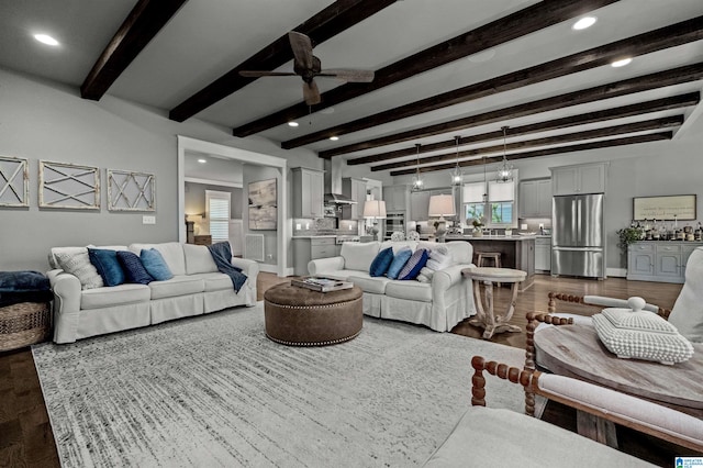 living room featuring beamed ceiling, wood-type flooring, and ceiling fan