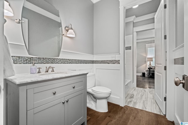 bathroom featuring vanity, toilet, wood-type flooring, and a bathing tub