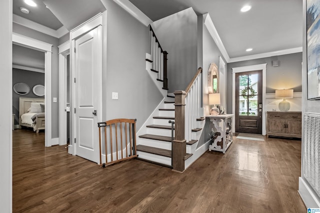 foyer entrance with ornamental molding and dark hardwood / wood-style flooring