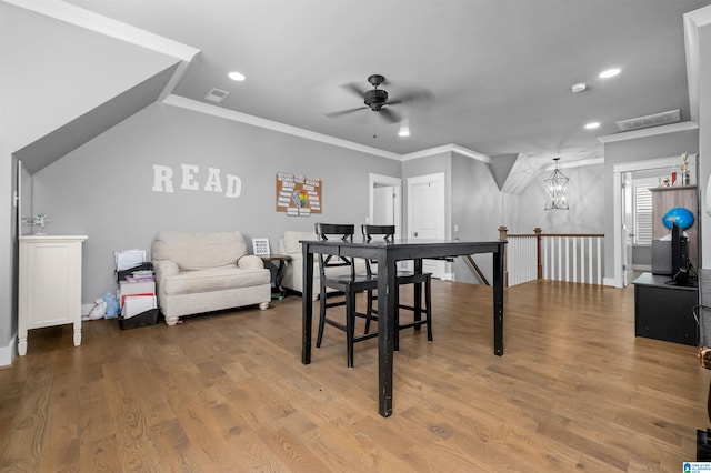 dining space with crown molding, ceiling fan with notable chandelier, and hardwood / wood-style floors