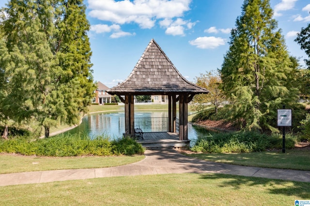 view of home's community with a gazebo, a water view, and a lawn