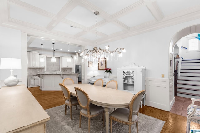 dining room featuring a notable chandelier, hardwood / wood-style floors, and coffered ceiling