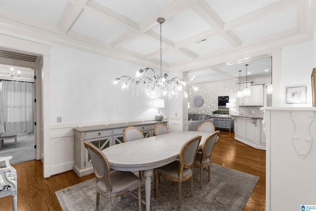 dining area featuring beam ceiling, coffered ceiling, dark wood-type flooring, and a chandelier