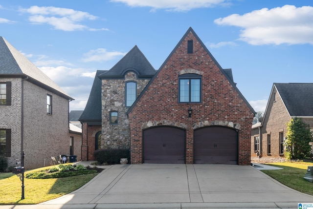 tudor home with a front yard and a garage