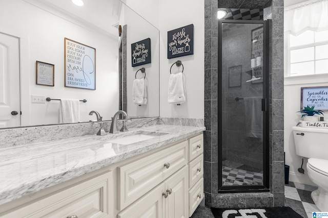 bathroom featuring vanity, toilet, and a shower with shower door