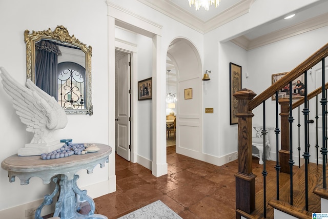 entrance foyer with crown molding and a chandelier