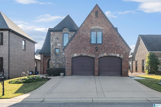 tudor-style house with a front lawn and a garage