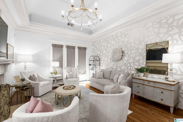 living room featuring crown molding, a tray ceiling, dark hardwood / wood-style flooring, and a chandelier