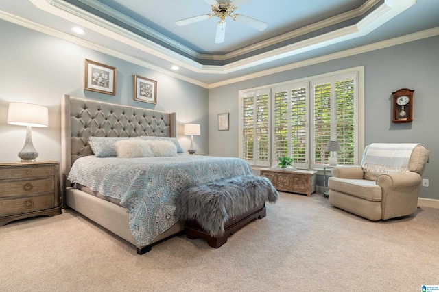 carpeted bedroom featuring crown molding, a raised ceiling, and ceiling fan