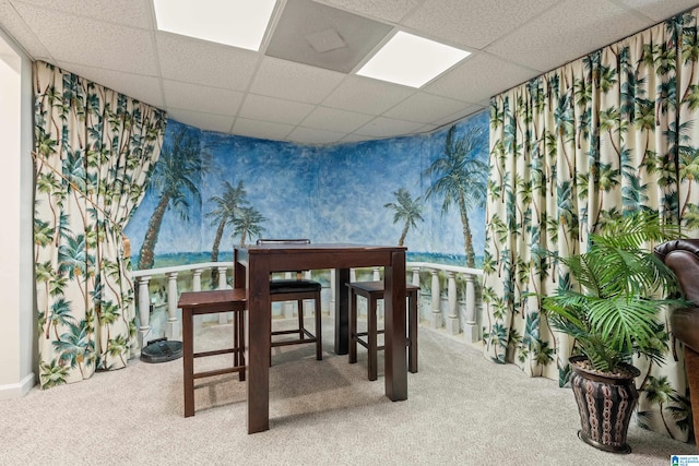 dining room featuring a drop ceiling and carpet