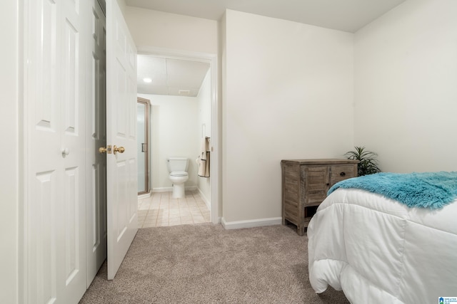 bedroom featuring light carpet and ensuite bath