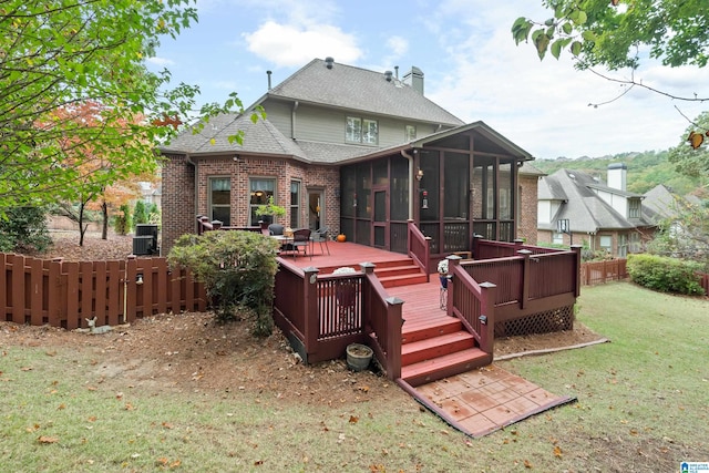 rear view of house with central AC, a wooden deck, a lawn, and a sunroom