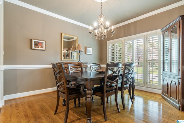 dining space featuring ornamental molding, an inviting chandelier, and light wood-type flooring