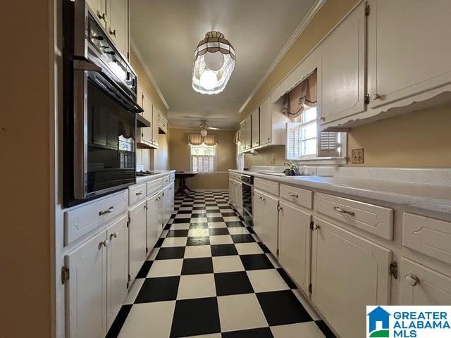 kitchen with crown molding, white cabinets, black appliances, and ceiling fan