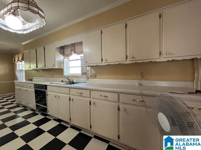 kitchen with sink, white cabinetry, and crown molding