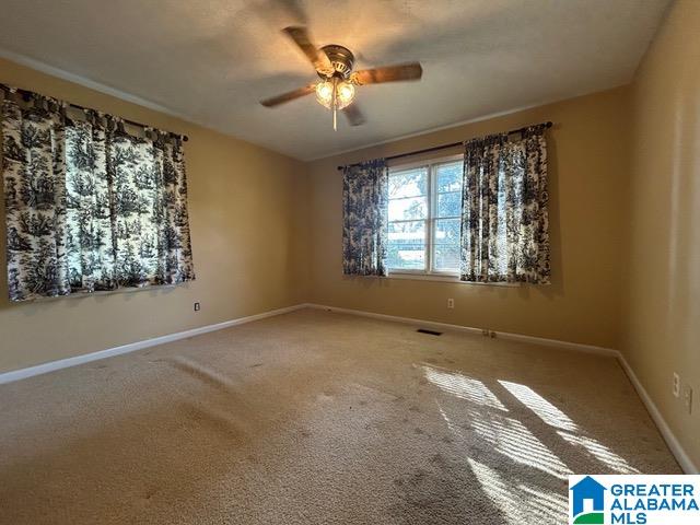 carpeted spare room with ceiling fan