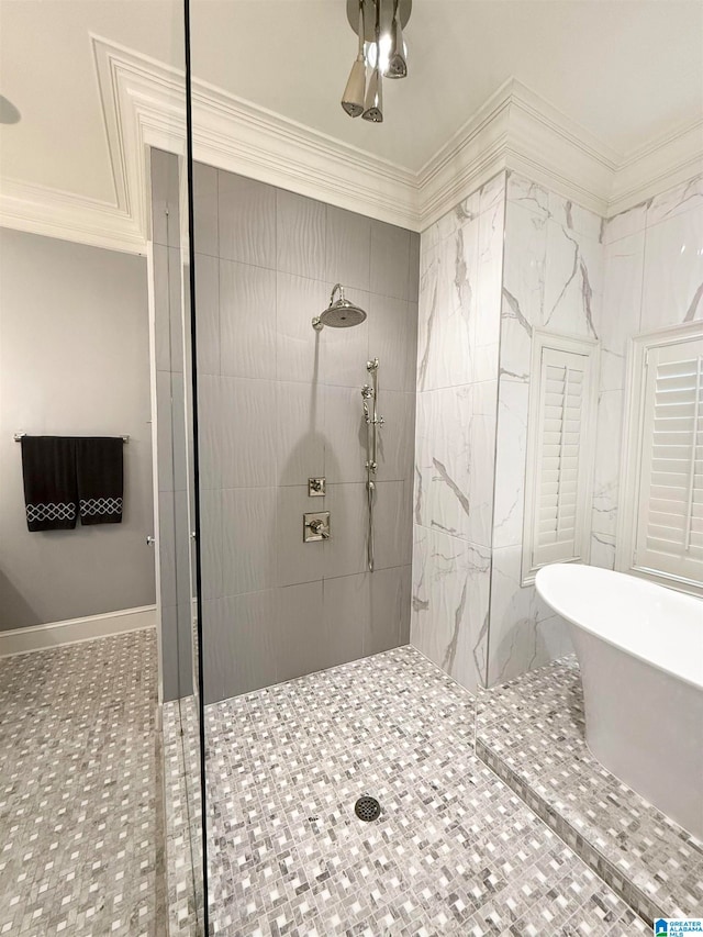 bathroom featuring ornamental molding, a soaking tub, tiled shower, and baseboards