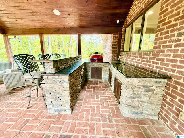 view of patio / terrace featuring outdoor wet bar, a sink, and area for grilling