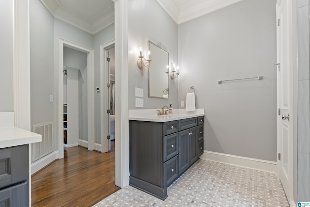 bathroom featuring ornamental molding, vanity, visible vents, and baseboards