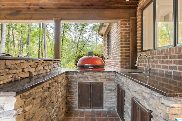 view of patio / terrace with exterior kitchen, area for grilling, and a sink