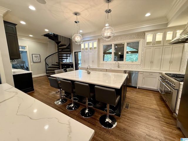 kitchen with a sink, visible vents, appliances with stainless steel finishes, light stone countertops, and crown molding