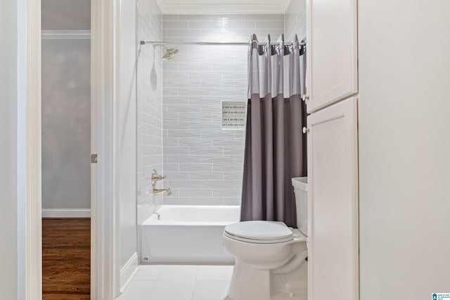 bathroom featuring toilet, baseboards, and shower / tub combo with curtain