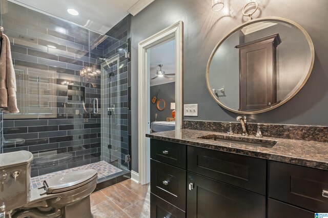 full bathroom featuring ceiling fan, vanity, a shower stall, and toilet