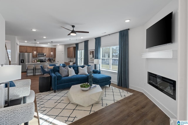 living room with ceiling fan and light wood-type flooring