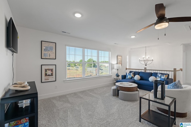 carpeted living room featuring ceiling fan with notable chandelier