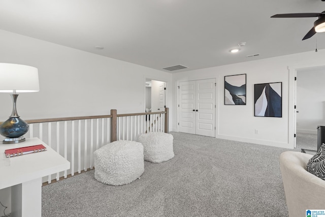 living area featuring ceiling fan and carpet flooring