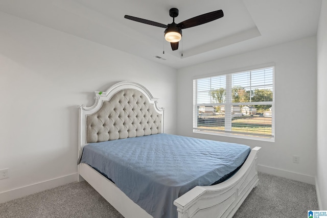 bedroom with ceiling fan, a raised ceiling, and carpet